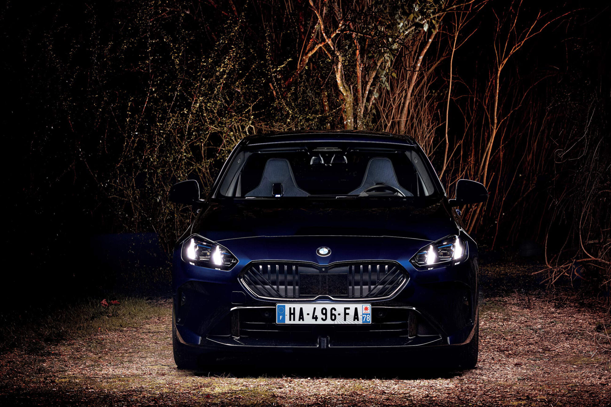 BMW 123 xDrive photographiée de face de nuit
